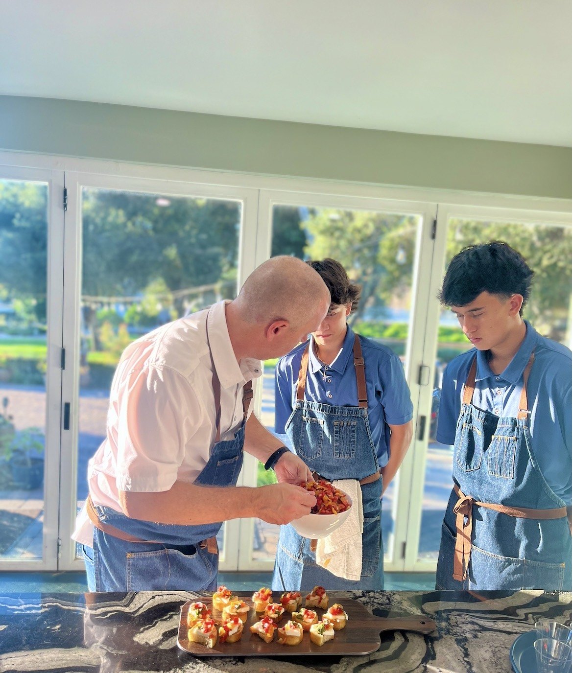 Chef Michael Rossi teaching his sons Maddox and Luca while cooking